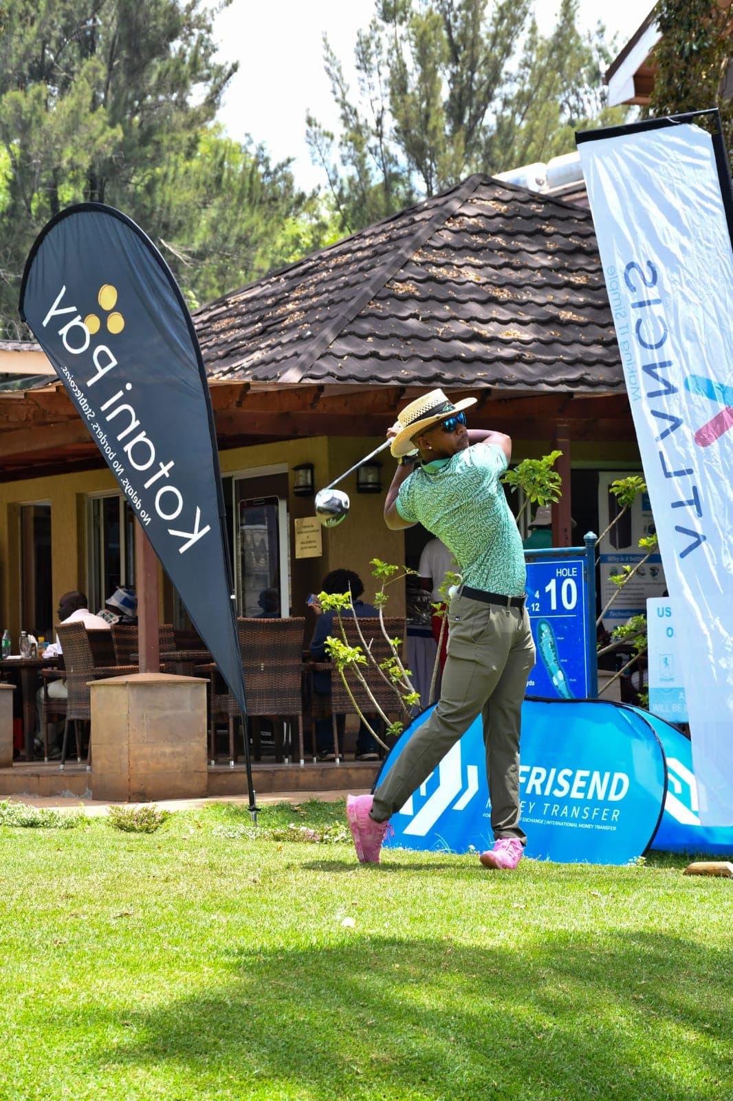 A golfer in a straw hat completing a drive at hole 10